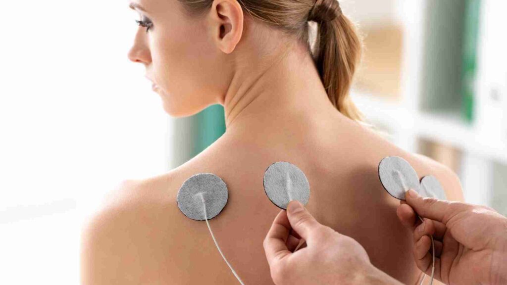 Person being placed electrodes on for tens therapy